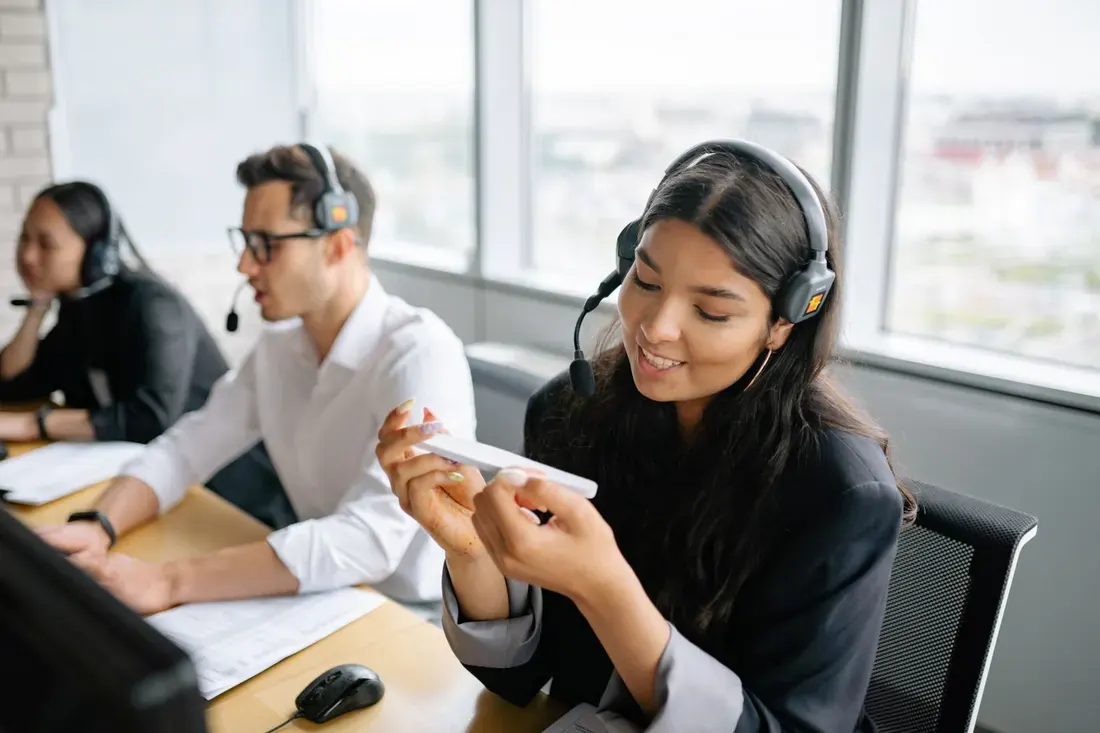 A smiling support agent wearing a headset